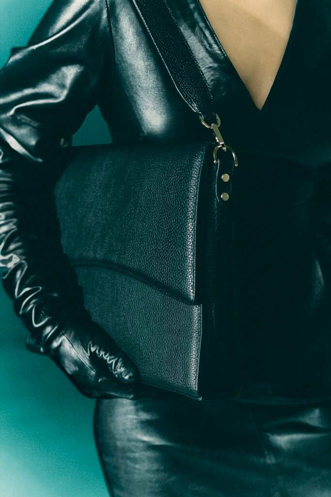 Close-up of a black leather shoulder bag and strap