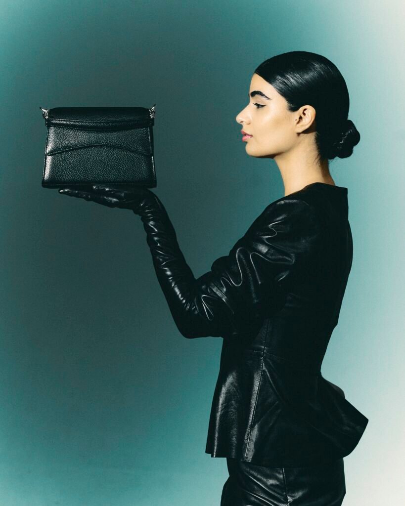 Side-profile model presenting a small black leather work bag