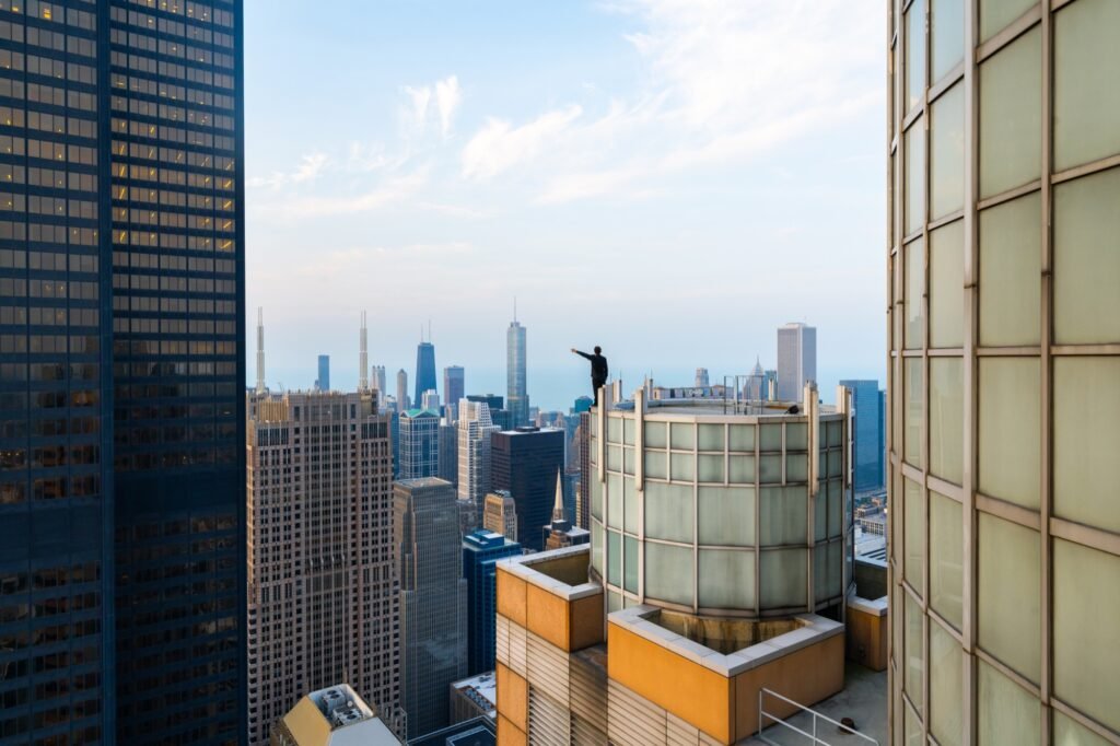 Urban explorer standing on a distant Chicago rooftop between skyscrapers