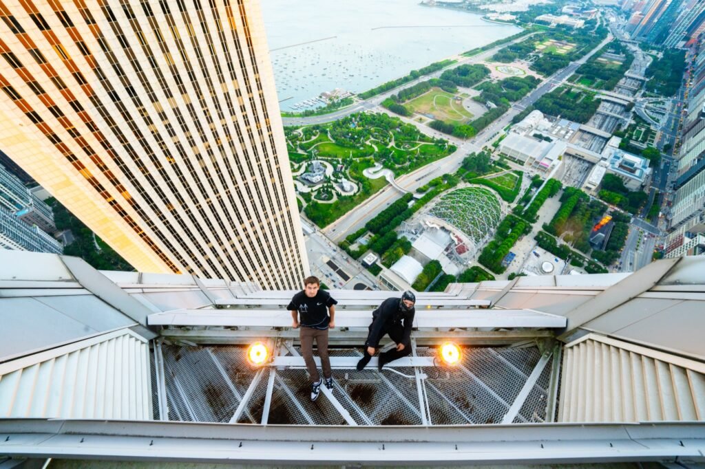 Two urban explorers standing on a skyscraper structure above Chicago