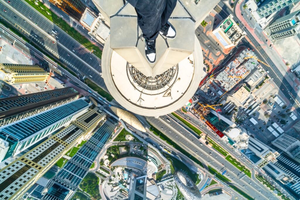 Urban explorer's feet above roads and skyscrapers in Dubai