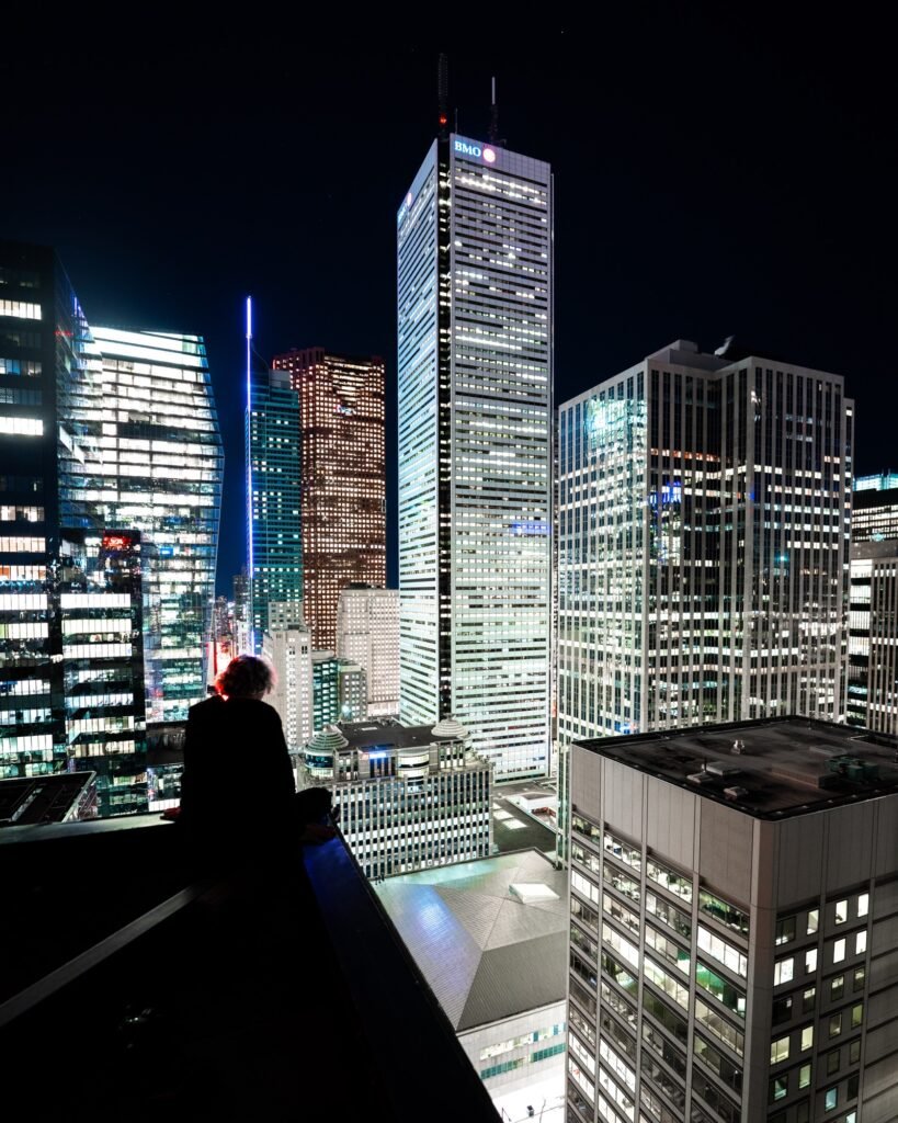Urban explorer overlooking illuminated downtown office towers at night