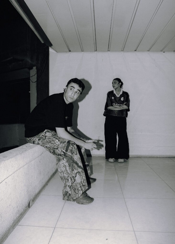 A black and white dramatic shot of Emad and Elika.